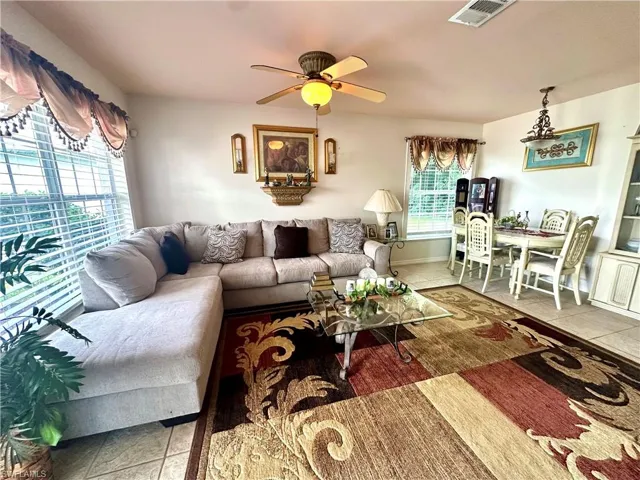 Tiled living room featuring a ceiling fan