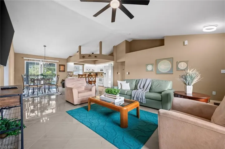 Tiled living area featuring a high ceiling and ceiling fan