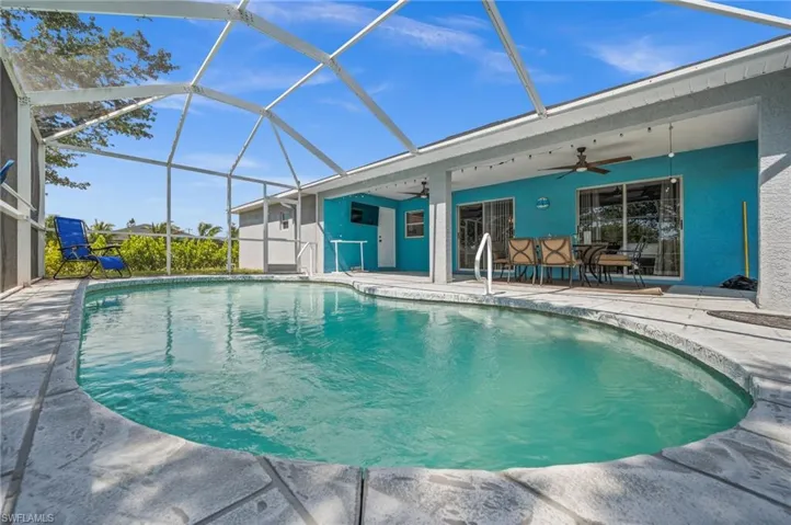 Outdoor pool with a sunroom, a patio area, a lanai, and outdoor dining space