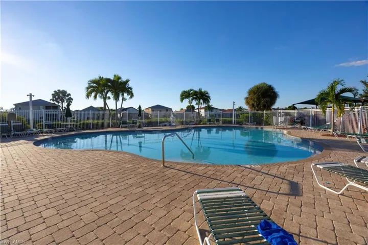 Community pool with a patio area and a residential view