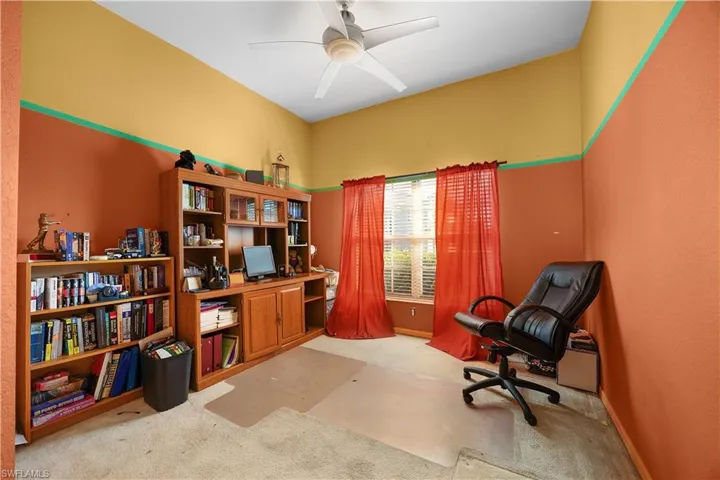 Office area with light carpet and a ceiling fan