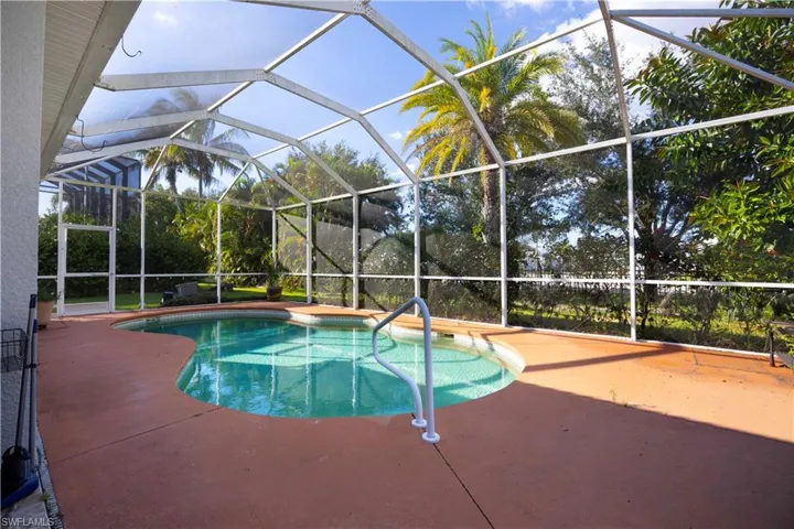 Outdoor pool with glass enclosure, a sunroom, and a patio area