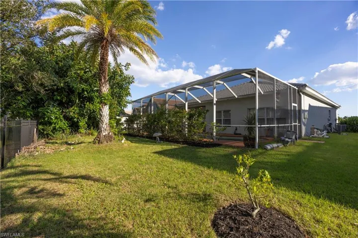 View of green lawn with a sunroom and a lanai