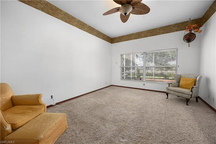 Sitting room with carpet and a ceiling fan