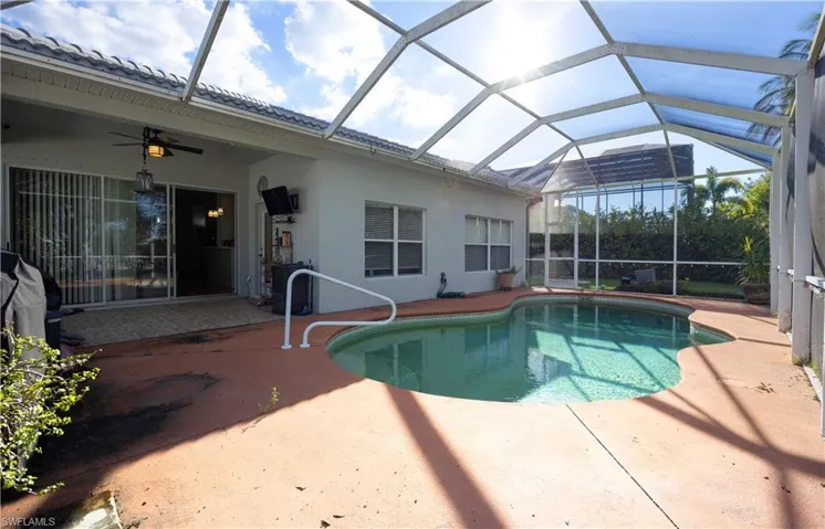 Outdoor pool featuring a sunroom, a lanai, a patio area, and a ceiling fan