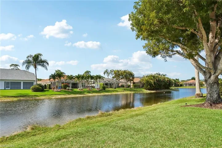 Waterfront lot featuring a manicured lawn, mature trees, and landscaping