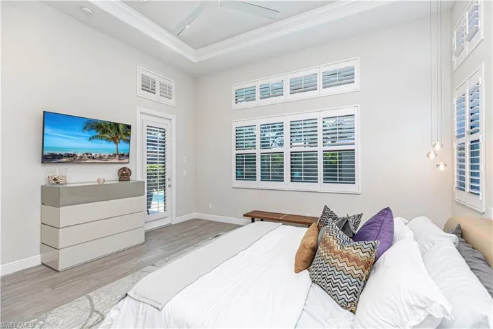 Master Bedroom with access to outside lanai, crown molding, wood finished floors, baseboards, and ceiling fan