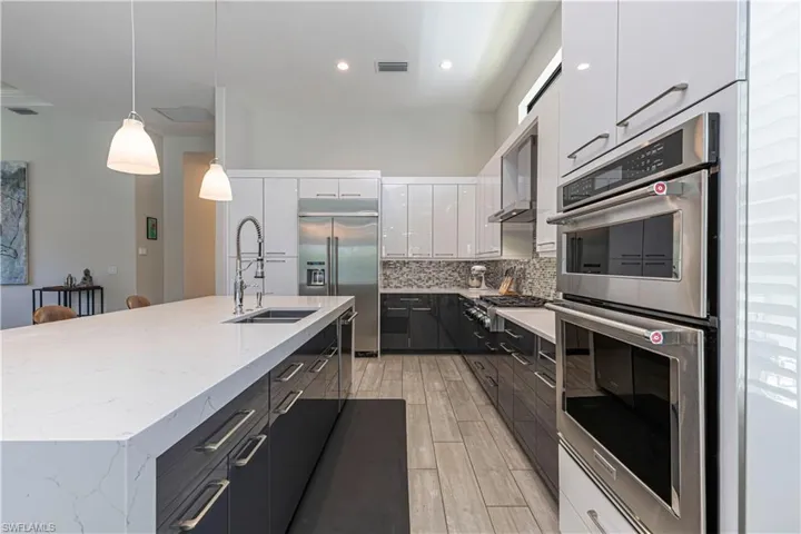 Kitchen with upgraded stainless steel appliances, quartz counters, and large island