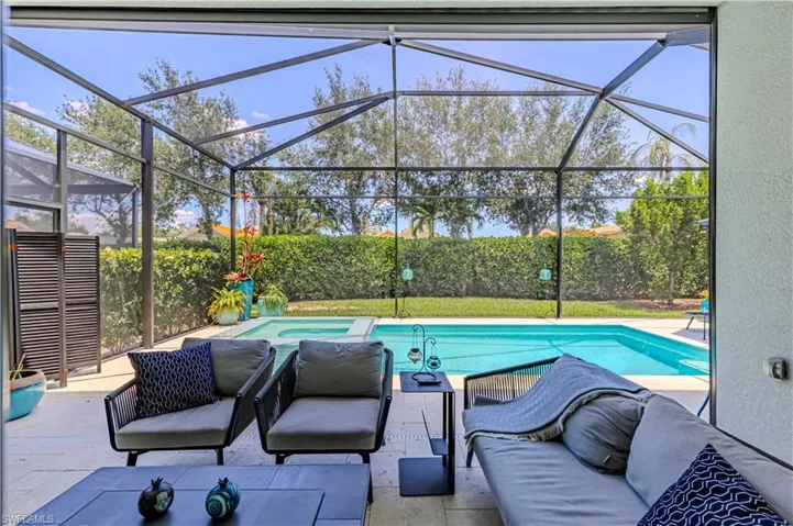View of swimming pool and hot tub and screened in lanai