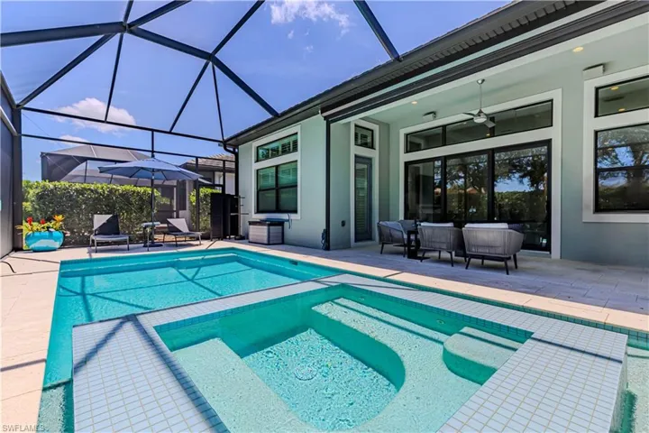 View of pool with a patio, a ceiling fan, a pool with connected hot tub, and screen enclosure