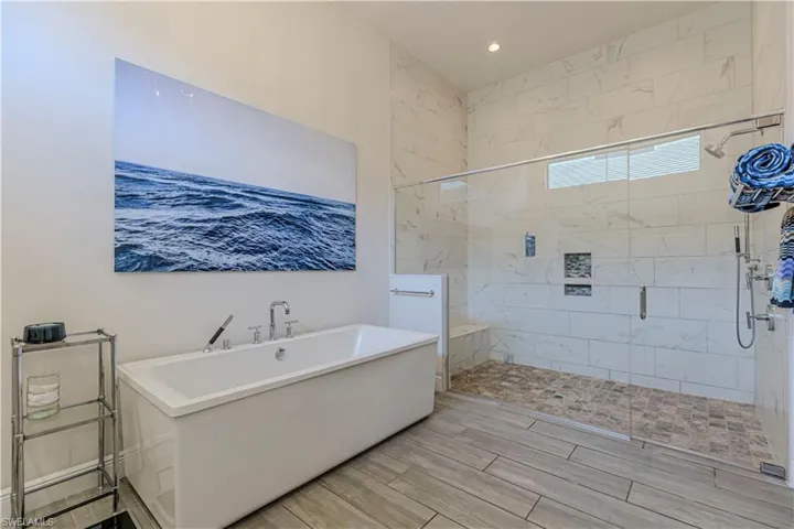 Master bathroom featuring a soaking tub and large walk in shower