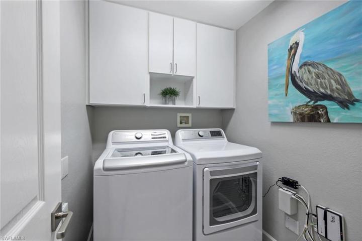 In home laundry room with great storage above washer/dryer.
