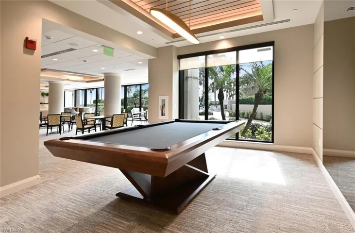 Recreation room featuring pool table, light carpet, and plenty of natural light
