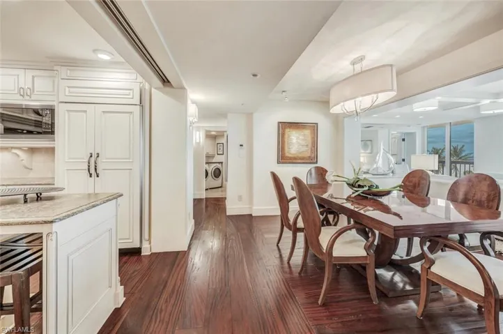 Dining room with wine cooler, separate washer and dryer, and dark hardwood / wood-style floors
