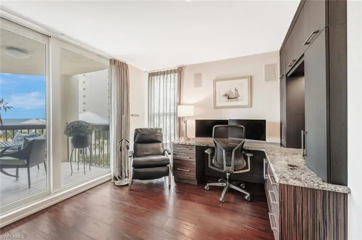 Home office featuring built in desk and dark wood-type flooring