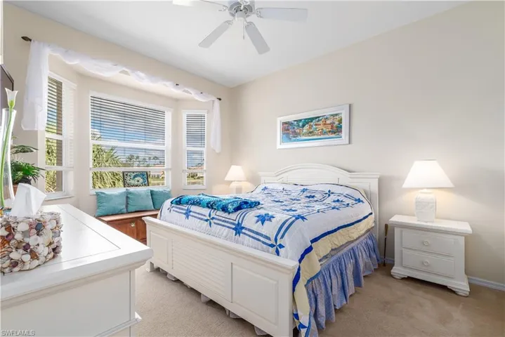Carpeted bedroom featuring ceiling fan