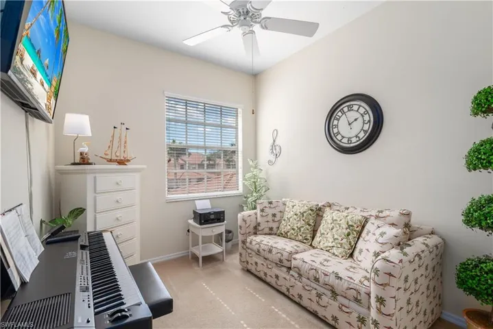 Carpeted living room with ceiling fan