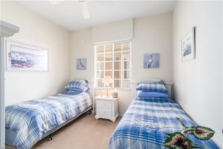 Carpeted bedroom featuring ceiling fan