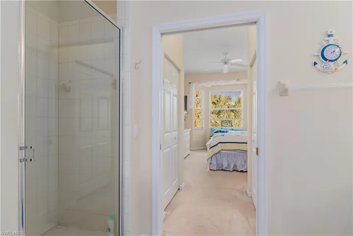 Bathroom with ceiling fan and a shower with shower door