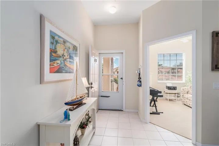 Doorway to outside featuring light carpet