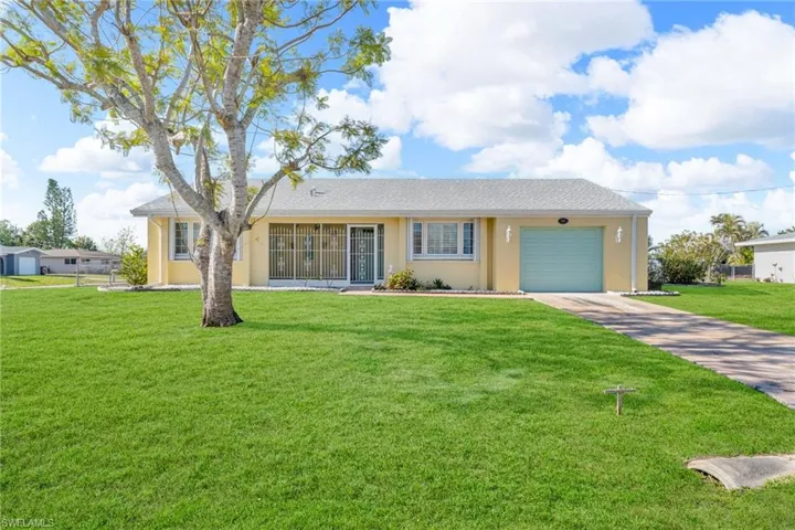 Ranch-style house featuring a garage and a front yard