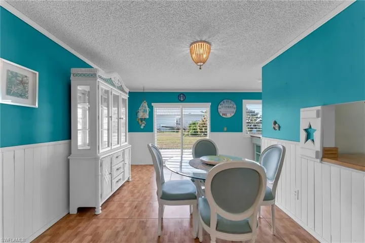Dining space with light tile patterned floors and a textured ceiling