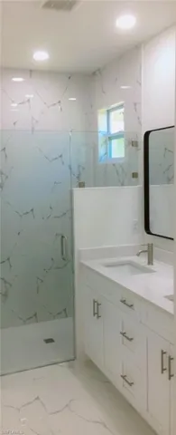 Bathroom featuring vanity, tile patterned flooring, and an enclosed shower