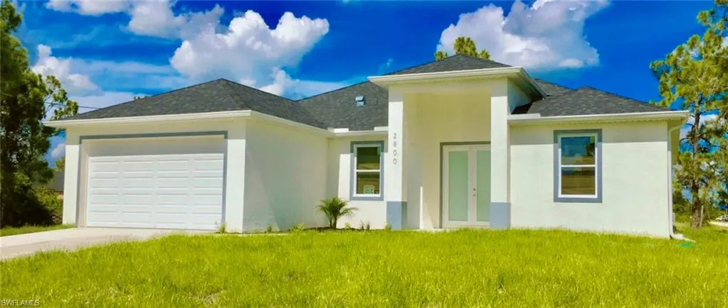 View of front of house with a garage and a front yard