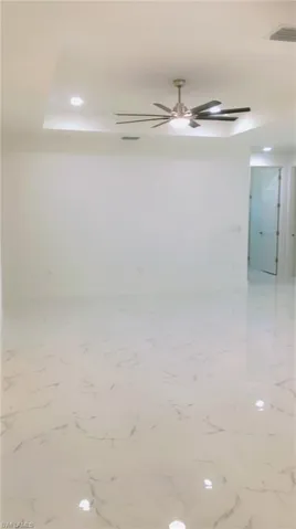Tiled empty room featuring ceiling fan
