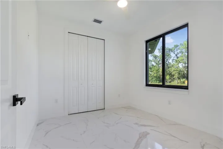 Unfurnished bedroom with baseboards, marble finish flooring, and a closet