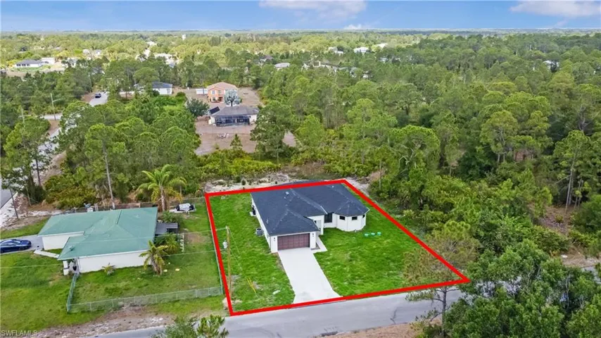 Aerial view of property and surrounding area with a heavily wooded area and property boundaries highlighted