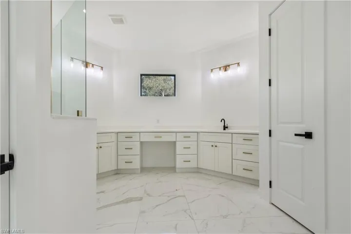 Full bath featuring marble look tiles and double vanity