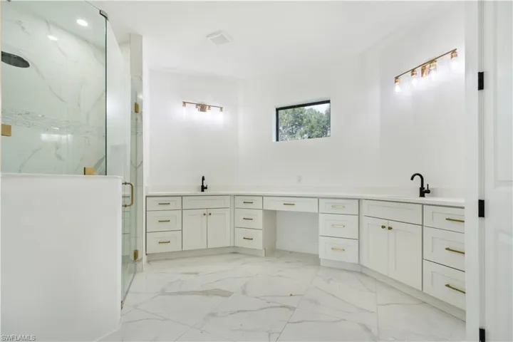 Full bathroom with a marble finish shower, double vanity, and marble finish floors