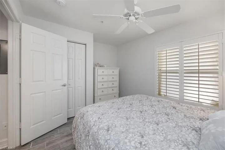Bedroom with a ceiling fan, wood tiled floor, and a closet
