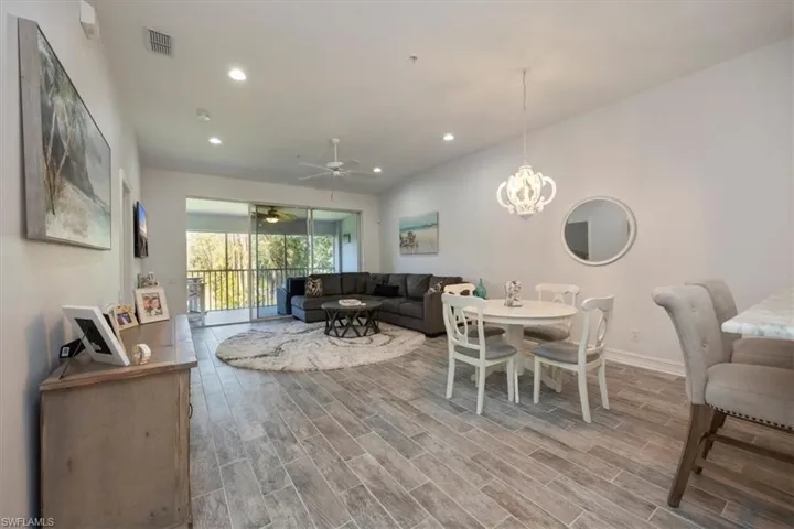 Dining room featuring baseboards, recessed lighting, visible vents, ceiling fan with notable chandelier, and wood finished floors