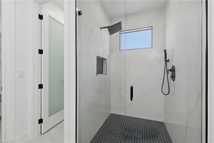 Full bathroom with a marble finish shower