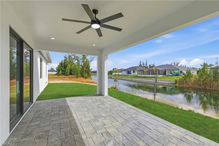 View of patio with a ceiling fan, a water view, and a residential view