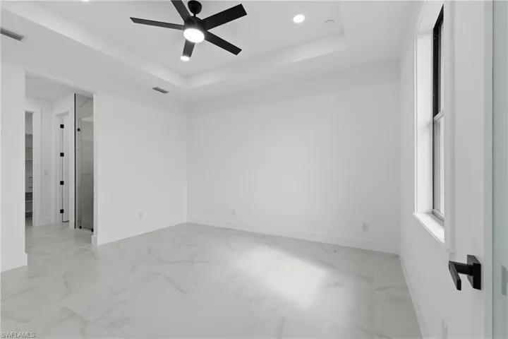 Spare room featuring recessed lighting, a tray ceiling, and ceiling fan