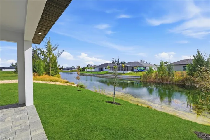 View of green lawn with a residential view and a water view