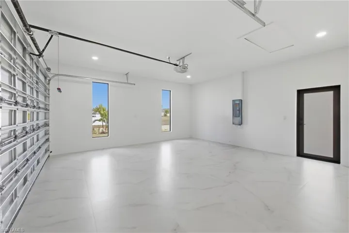 Garage featuring recessed lighting and electric panel