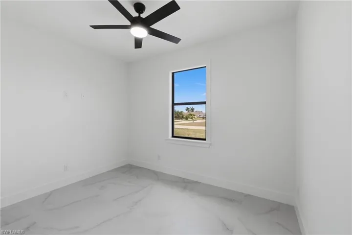 Unfurnished room with a ceiling fan and marble finish floors