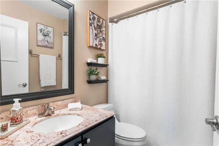 2nd bathroom offers a shower/tub combination. single vanity.