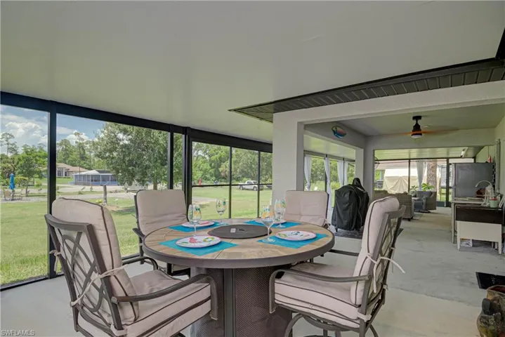 Sunroom with outdoor dining space, concrete floors, and a ceiling fan