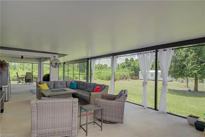 Sunroom featuring an outdoor living space with a fire pit and ceiling fan