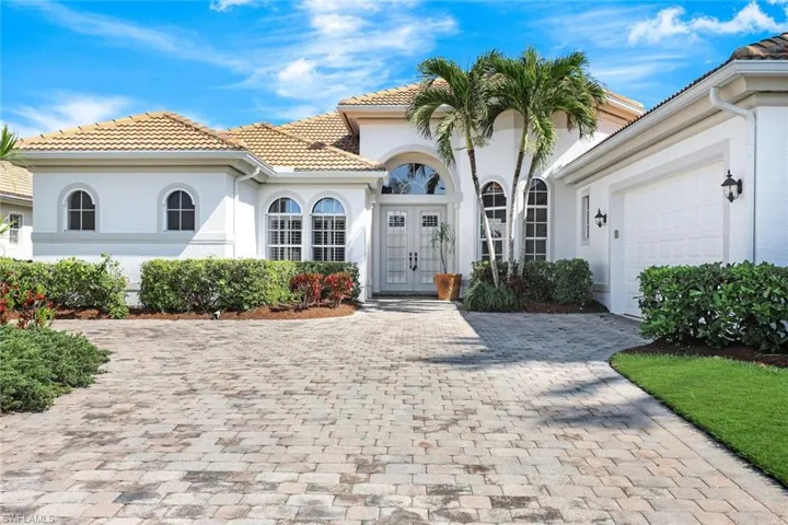 Mediterranean / spanish-style home featuring an attached garage, driveway, a tile roof, and stucco siding