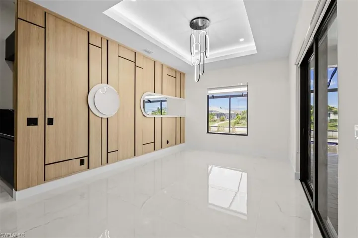 Spare room featuring recessed lighting, marble finish floor, baseboards, and a tray ceiling