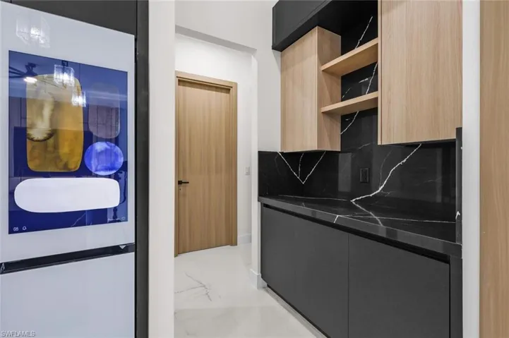 Kitchen featuring open shelves, tasteful backsplash, marble finish floor, and modern cabinets