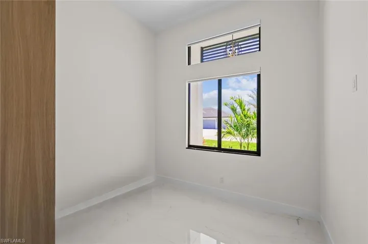 Spare room with marble finish floor and baseboards