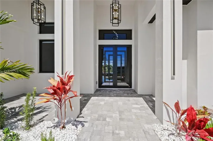 View of exterior entry featuring french doors and stucco siding