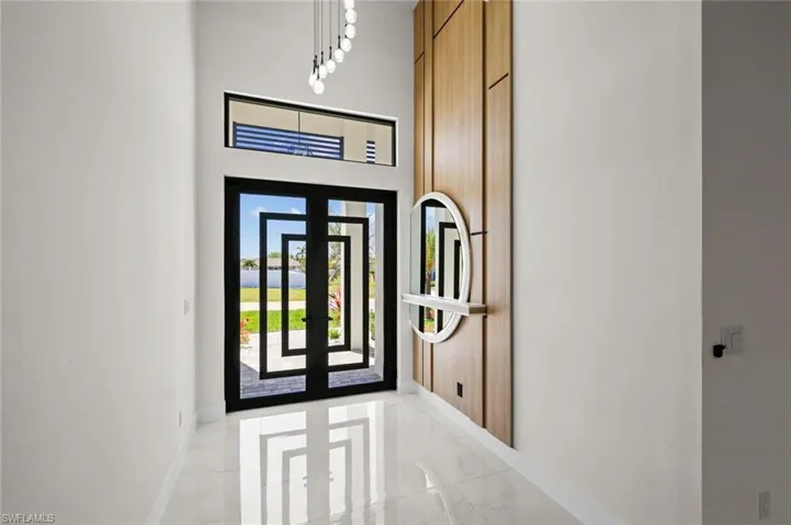 Foyer entrance with baseboards, marble finish floor, and a towering ceiling